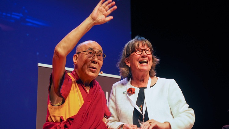 Su Santidad el Dalái Lama saludando a los nietos de la Presidenta del IM Birthe Müller mientras se encuentran juntos en el escenario al concluir su charla en Malmö, Suecia, el 12 de septiembre de 2018. Foto de Jeremy Russell