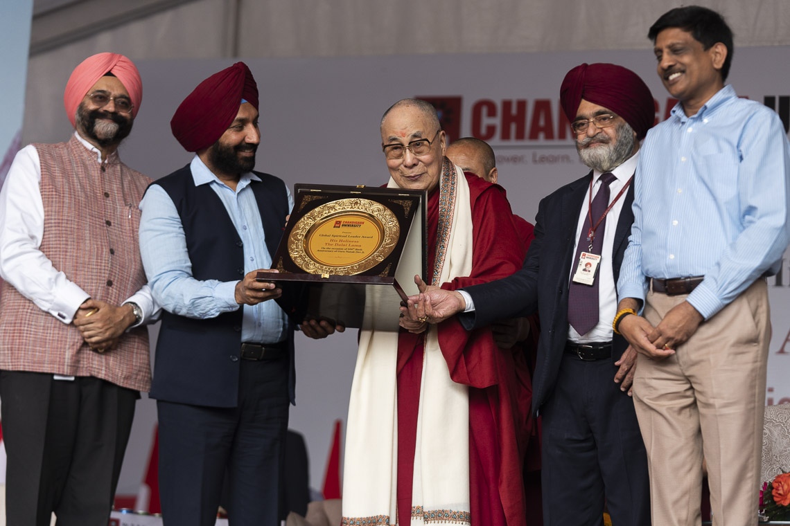 Su Santidad el Dalái Lama sostiene una placa que simboliza el Premio al Liderazgo Global que le fue entregado por la Universidad de Chandigarh en Chandigarh, India, el 15 de octubre de 2019. Foto de Tenzin Choejor