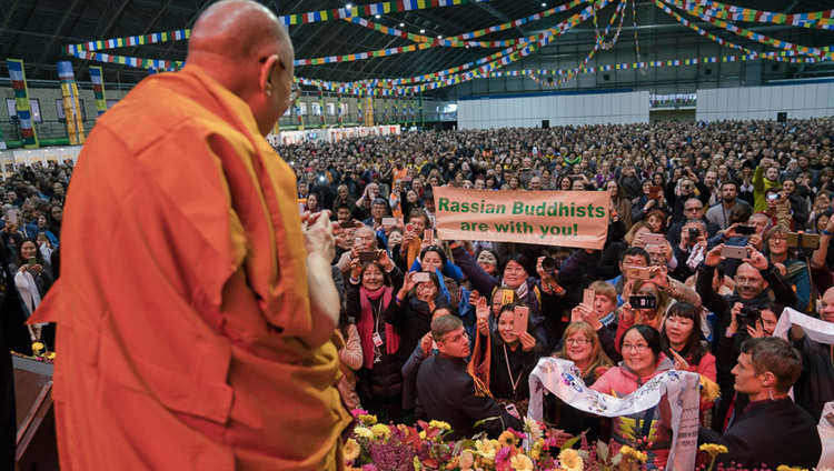 Su Santidad el Dalái Lama saluda al público de 4.500 personas a su llegada al escenario al comienzo de su enseñanza en la sala Skonto de Riga, Letonia, el 10 de octubre de 2016. Foto/Tenzin Choejor/OHHDL