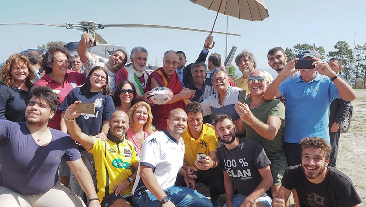 Su Santidad el Dalái Lama con miembros del club de rugby dominical en el campo que se utilizó como helipuerto para su viaje a Palermo desde Messina, Sicilia, Italia el 17 septiembre 2017. Foto Jeremy Russell
