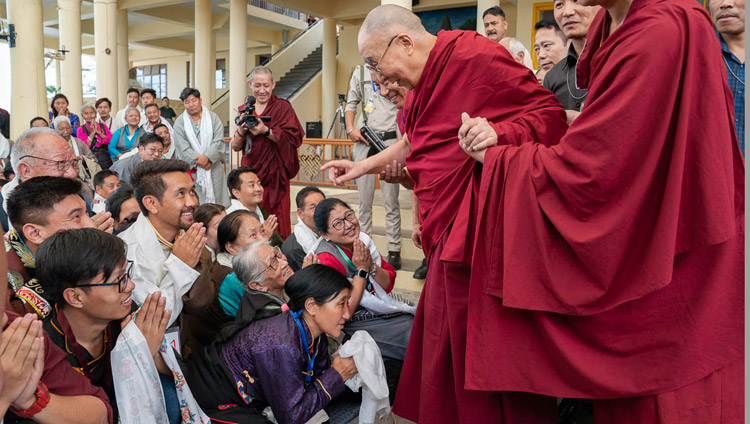 Su Santidad el Dalái Lama saluda a los miembros de la audiencia cuando parte hacia su residencia al concluir su reunión con los participantes en una Conferencia Internacional sobre el Enfoque del Camino Medio en el patio del Templo Principal Tibetano en Dharamsala, HP, India, el 30 de mayo de 2018. Foto de Tenzin Choejor