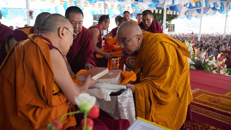 El Abad del Monasterio de Namgyal, Thomtog Rinpoché, presenta a Su Santidad el Dalái Lama las más recientes publicaciones de las obras sobre Ciencia y Filosofía en los Clásicos del Budismo Indio durante la celebración de Ganden Ngamchö en Mundgod, Karnataka, India, el 21 de diciembre de 2019. Foto de Lobsang Tsering