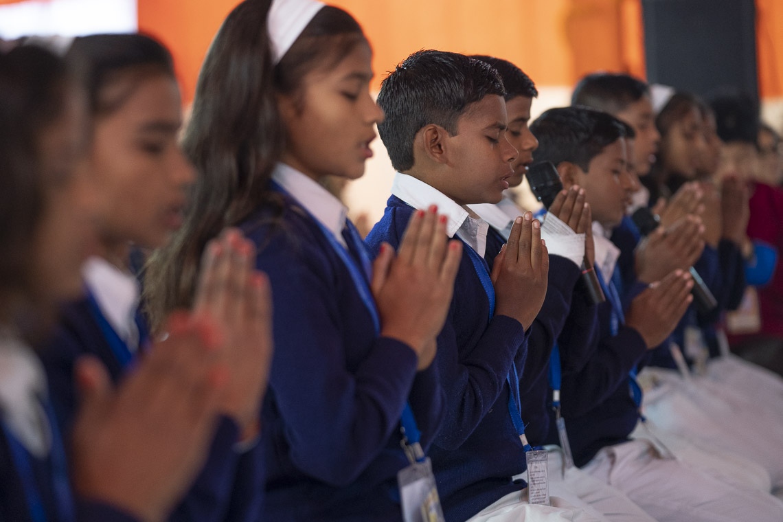 Un grupo de niños locales en uniforme escolar recitando el Mangala Sutta en Pali al comienzo de la enseñanza de Su Santidad el Dalái Lama en Sankisa, UP, India, el 3 de diciembre de 2018. Foto de Lobsang Tsering