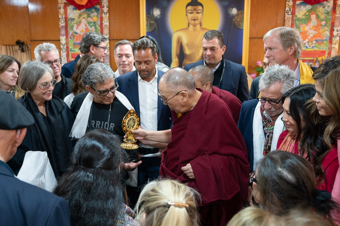 La audiencia se reúne en torno a Su Santidad el Dalái Lama mientras entrega una Rueda del Dharma a Deepak Chopra al final de su reunión en Dharamsala, HP, India, el 11 de febrero de 2019. Foto de Tenzin Choejor