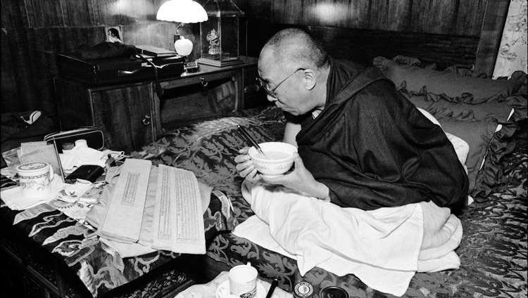 Su Santidad el Dalái Lama leyendo textos budistas mientras desayuna en su residencia de Dharamsala, HP, India, el 15 de agosto de 2004. (Foto cortesía de Manuel Bauer)